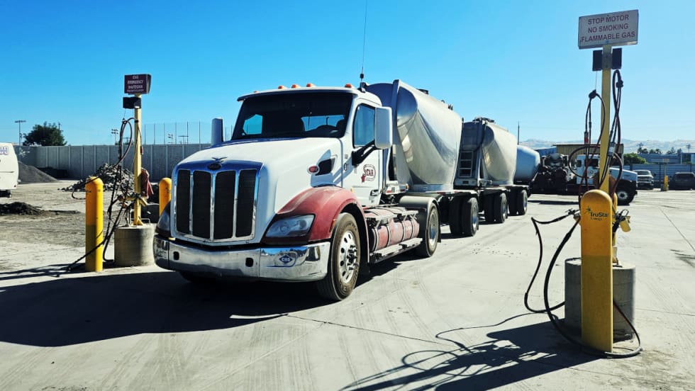 Truck parked with two bulk haul trailers behind it.