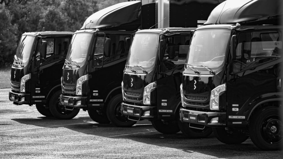Angled view of cabs of four cargo trucks.