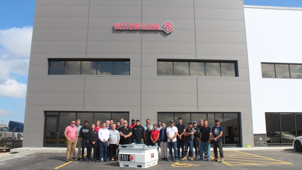 group standing in front of large industrial building