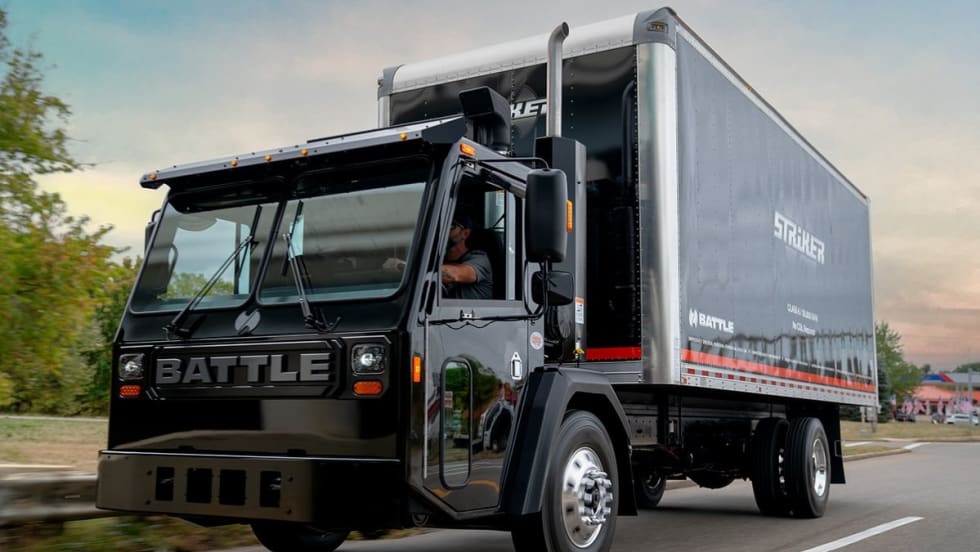 A black Class 6 box truck is shown on a road.