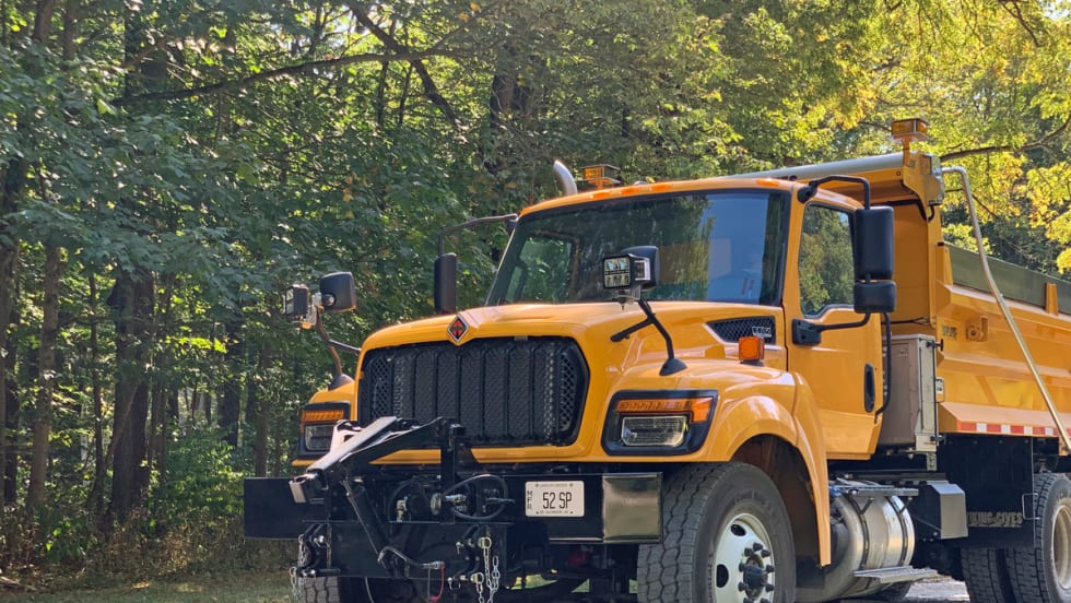 Yellow International HV truck on gravel road in the woods