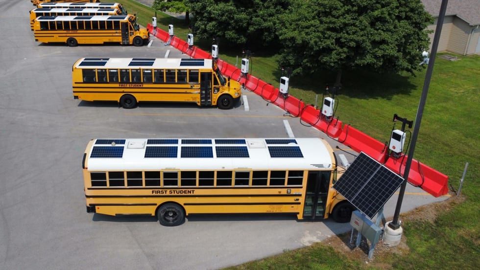 school buses with solar panels at charging stations