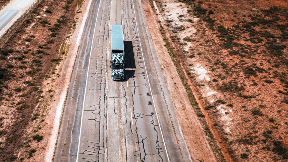 Overhead photo of tractor trailer traveling on a closed section of highway.