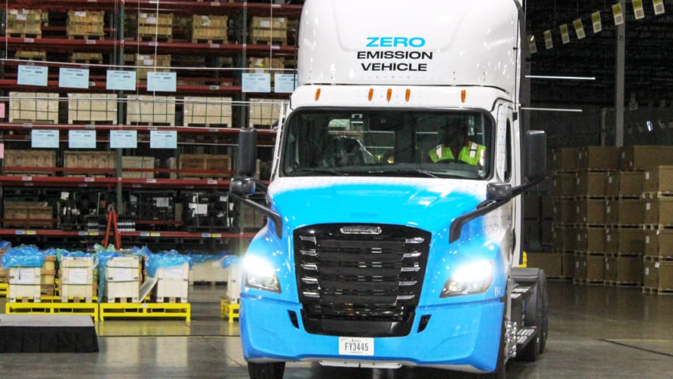 Photo of a Freightliner eCascadia truck facing the camera inside a warehouse.