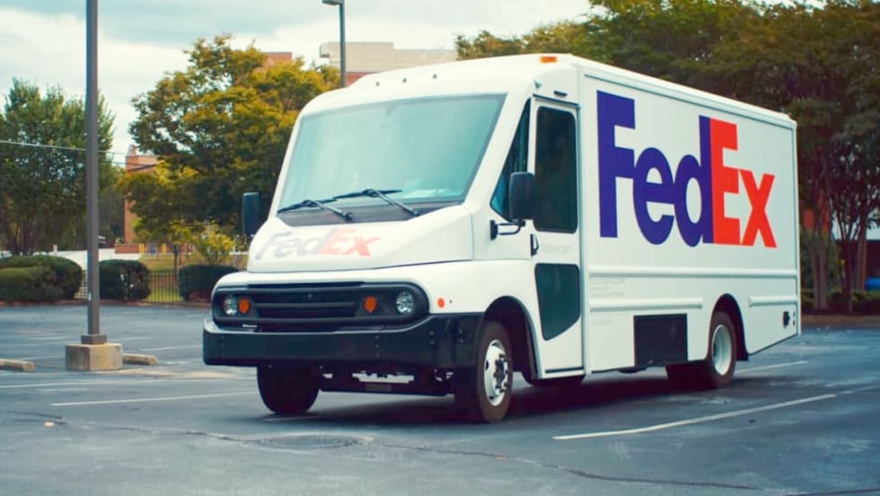 while electric delivery step van with FedEx logos