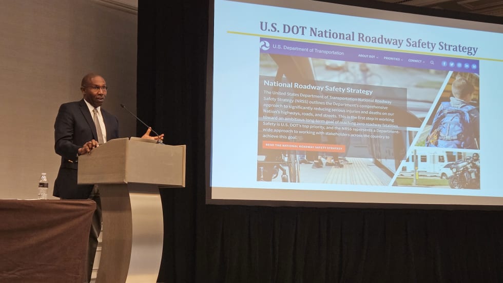 A man stands at a podium and presents to a crowd