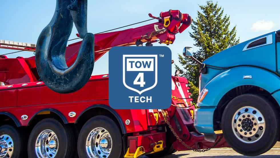 Tow truck towing a big rig with Tow4Tech logo
