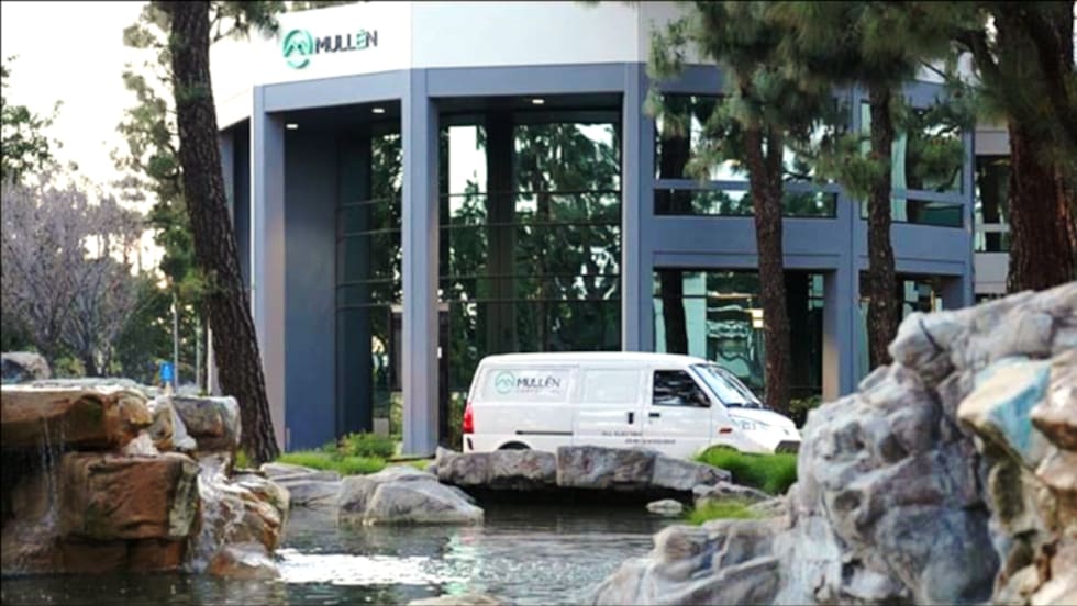 Image of an EV van parked in front of Mullen Automotive headquarters.