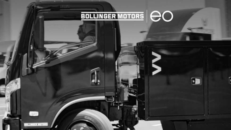 Photo of a black battery-elecdtric commercial truck with logos for EO Charging and Bollinger Motors.