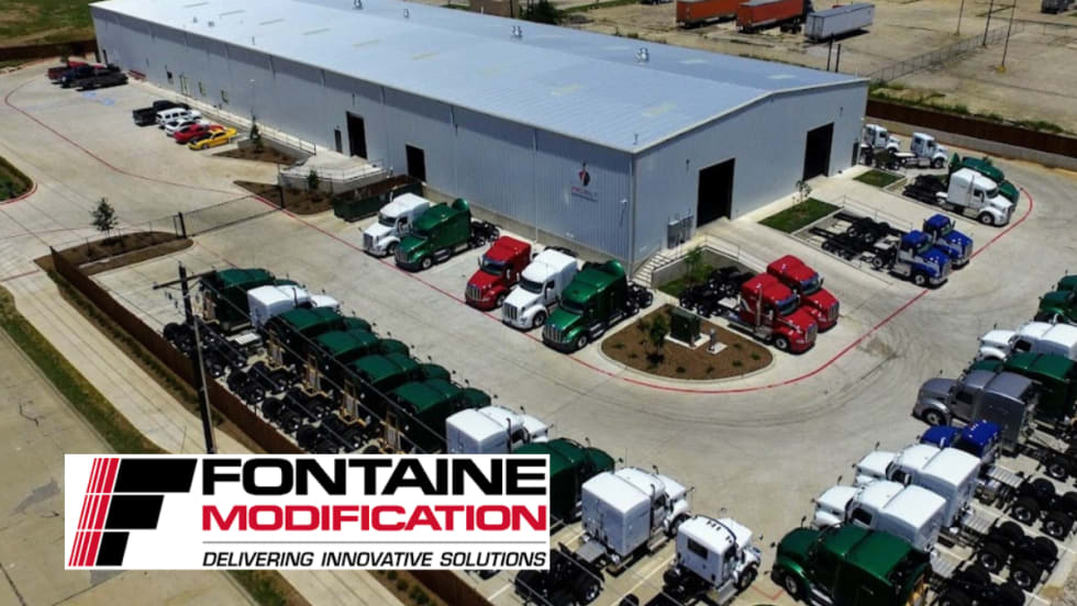 Aerial photo of a truck modification garage and trucks in the parking lot.