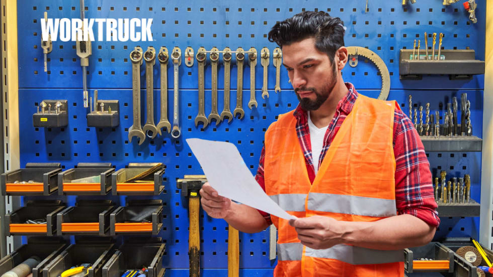 Technician in front of tools looking at a work order