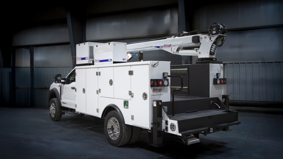 White service truck parked in a darkened industrial room. 