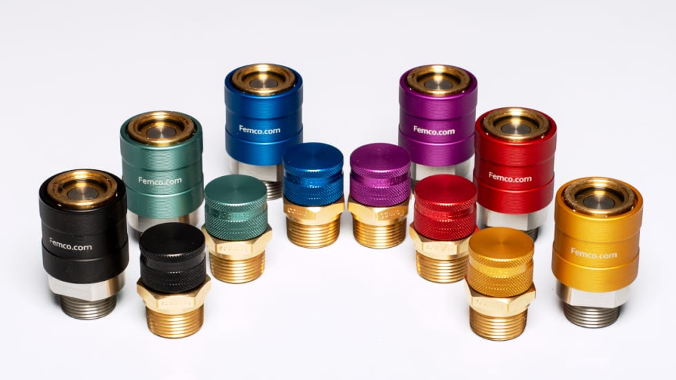 Various colors of fluid drain plugs against a white background.