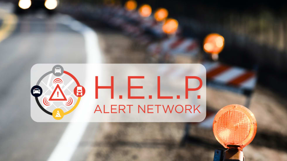 Background image of traffic warning lights along edge of road approaching a curve and inset logo for H.E.L.P. Alert Network.