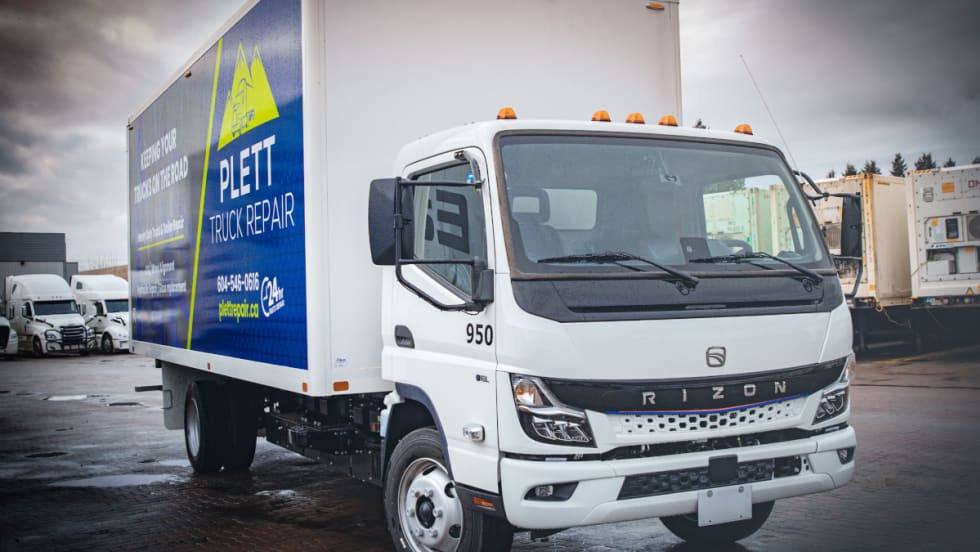front quarter view of a medium-duty white electric truck with a box