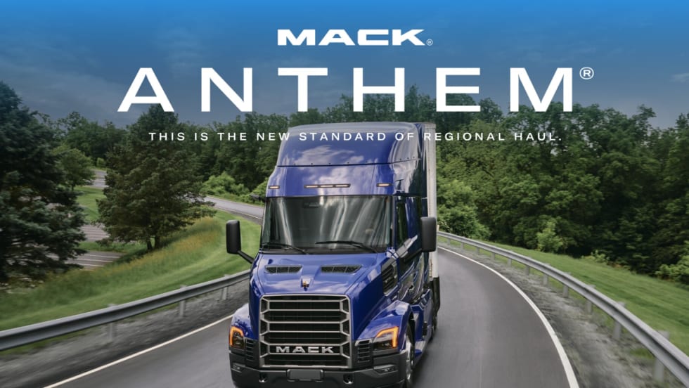 Mack tractor trailer driving on a road, shown from the front view.