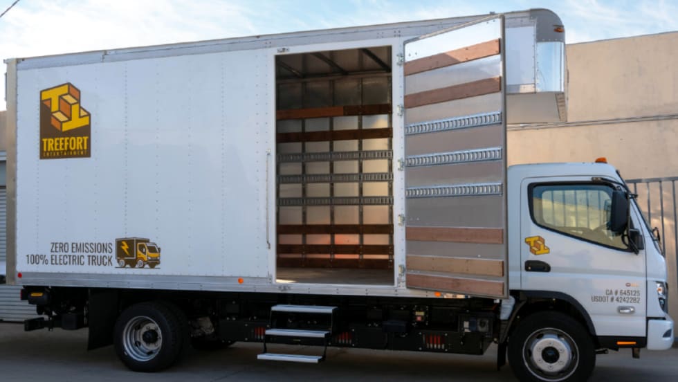 A white Treefort electric box truck with its side door open, showing an empty cargo area.