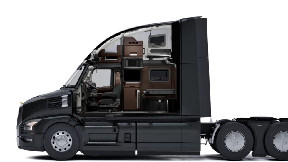 Side cutaway view of a Mack Pioneer truck cab showing the driver’s seat and sleeper area with storage cabinets, microwave, bunk beds, and workspace inside the cab interior.