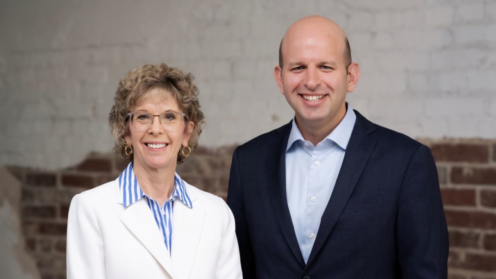 ArcBest's Judy McReynolds in white blazer next to Seth Runser in blue blazer.