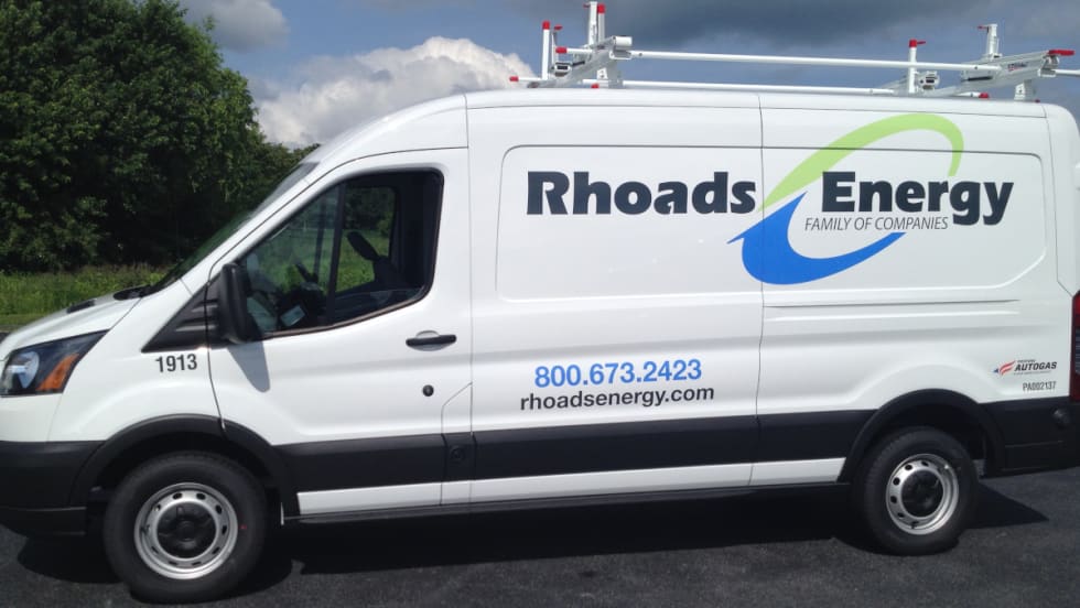 Photo of the side of a Ford Transit service van with company logo for Rhoads Energy.