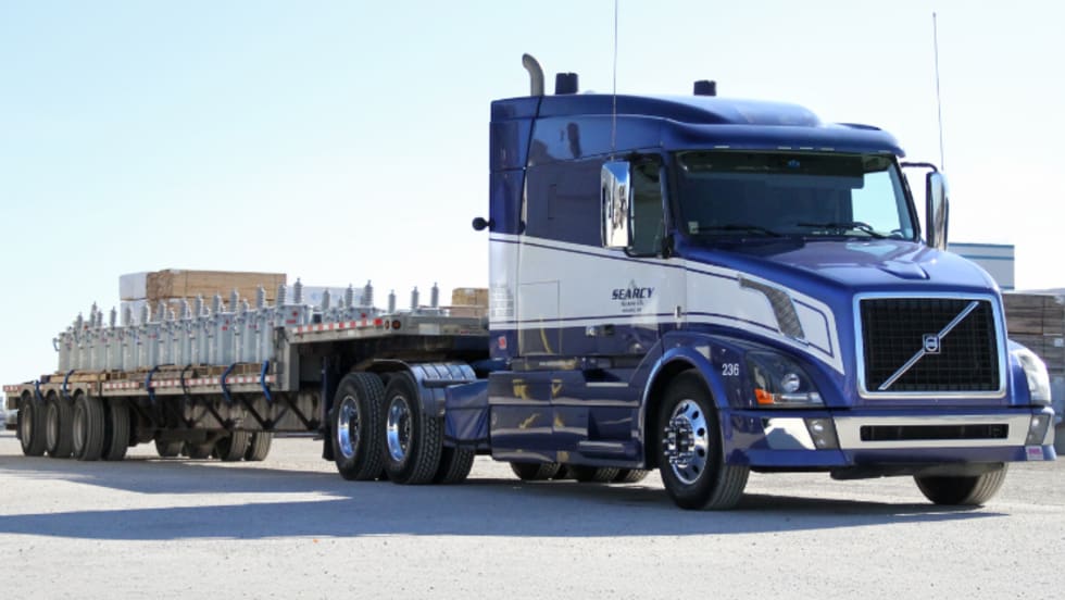 Photo of a Searcy truck pulling an open deck trailer