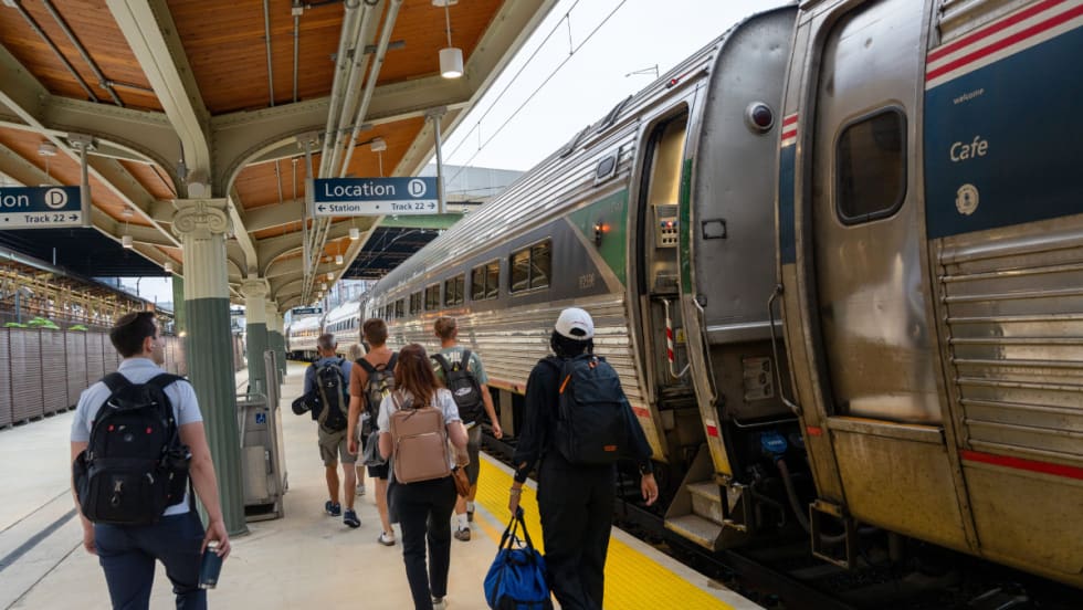 Passengers board an Amtrak train at Washington Union Station’s new Track 22 platform under a covered structure with clear signage and updated accessibility features.