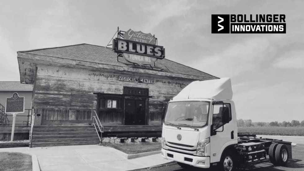Bollinger Innovations electric cab chassis truck parked outside the Gateway to the Blues Visitors Center in Tunica, Mississippi, with the historic sign and building in the background.