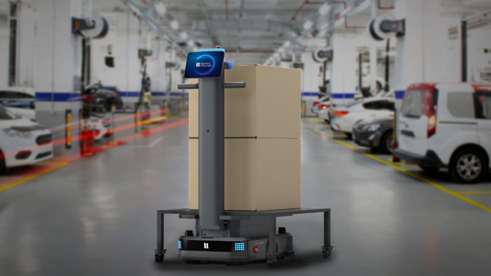Autonomous Relo parts delivery robot from Reynolds and Reynolds carrying boxes inside an automotive service department.
