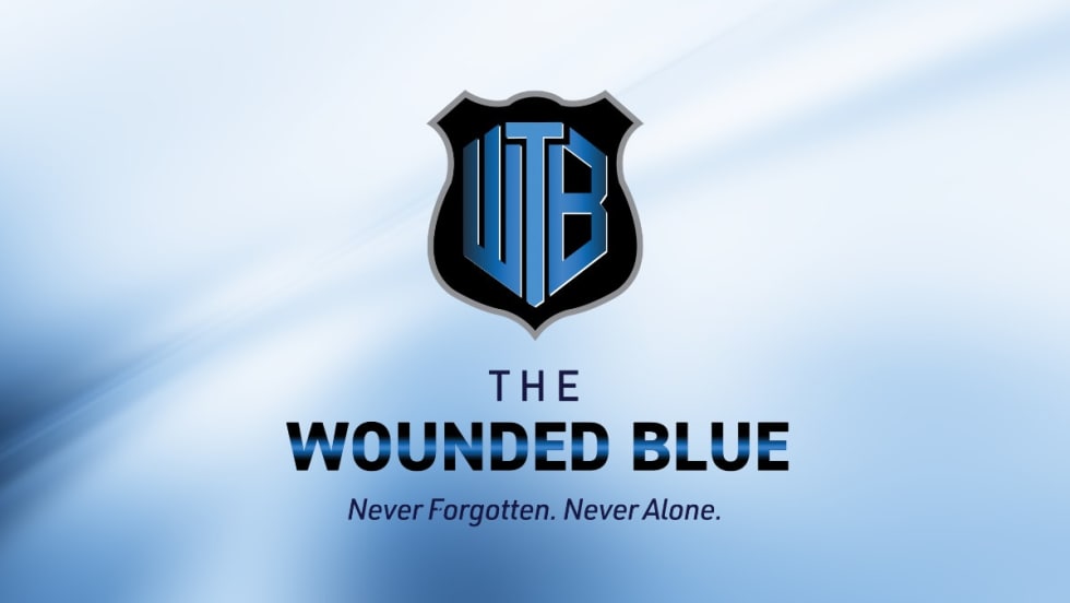 The Wounded Blue logo: shield emblem with WB letters in blue and black