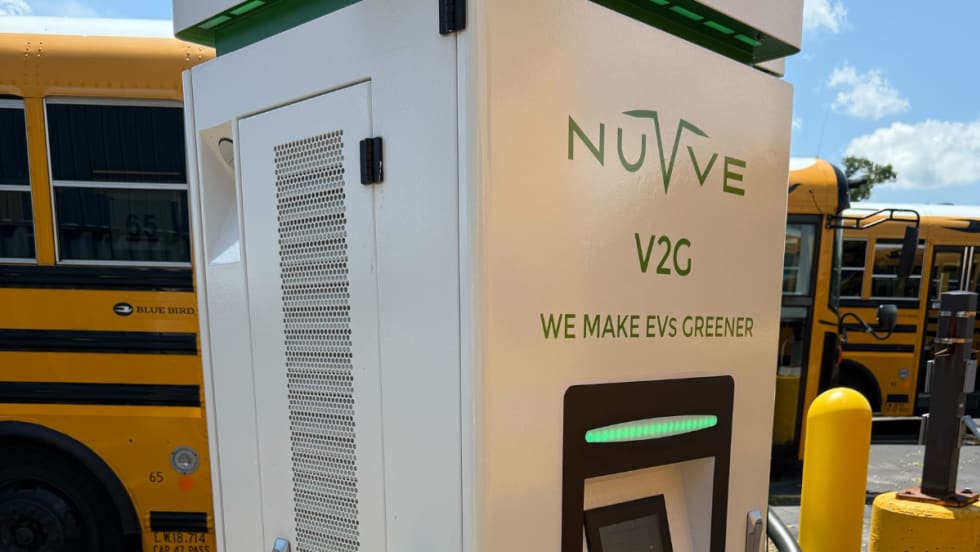 photo of a school bus charging at a Nuvve-branded EV station