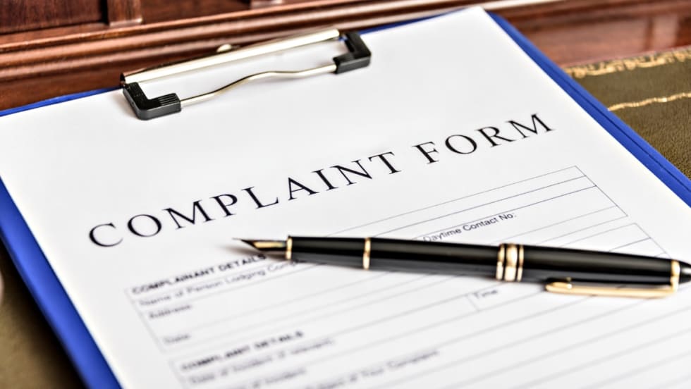 Complaint form on clipboard with black pen, ready for filing a formal written complaint