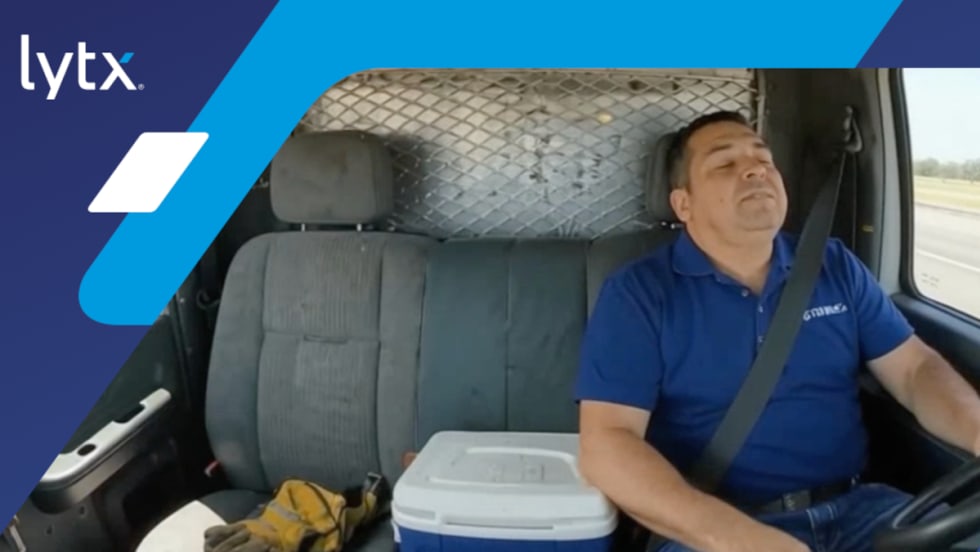 Truck driver asleep at the wheel, with logo for Lytx in the upper left corner.