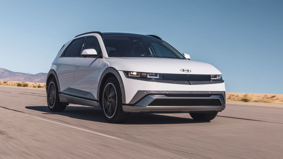 A white 2026 Hyundai IONIQ 5 electric crossover driving on a desert highway under a clear blue sky.