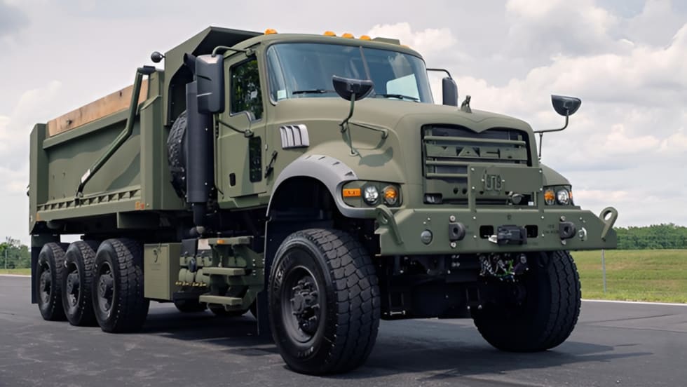 Military dump truck shown from the front quarter low angle.