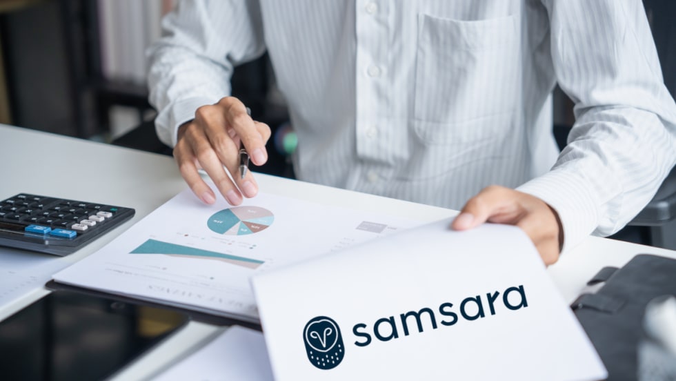 Close-up of a person reviewing charts and a document featuring the Samsara logo, representing research findings on disaster preparedness and operational resilience.