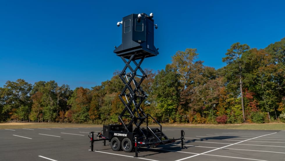 view of a mobile observation trailer deployed in a parking lot against a blue sky