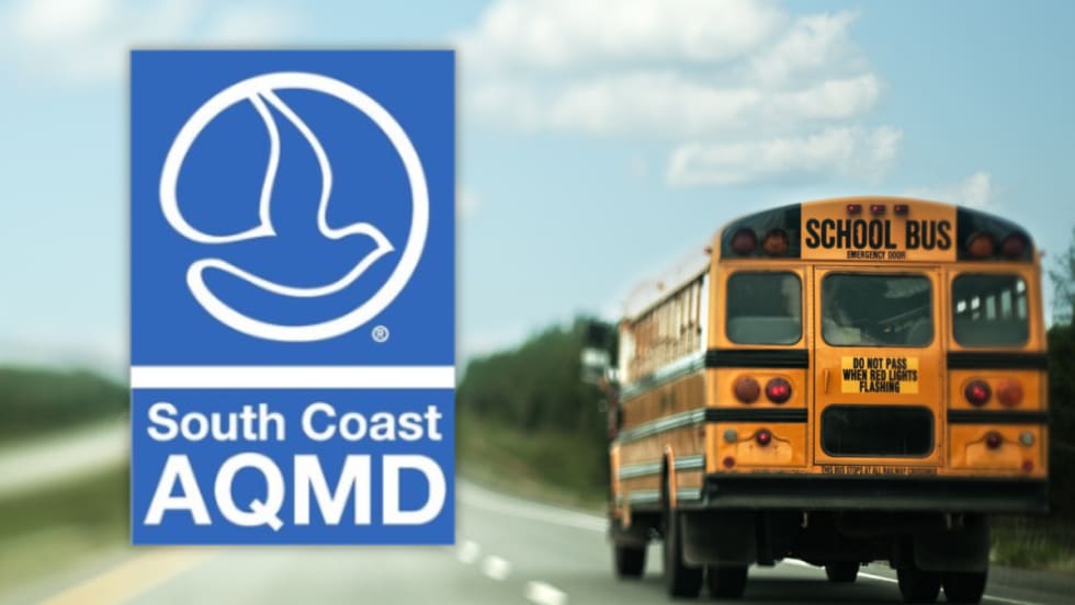 South Coast AQMD logo alongside a school bus driving on a roadway, representing new funding to replace diesel buses with zero-emission models for Southern California school districts.