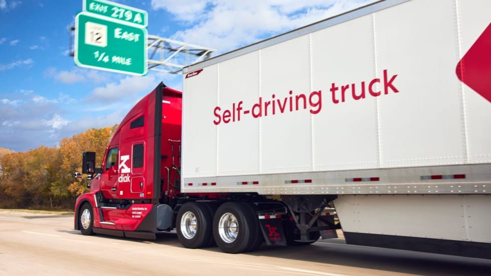 Red Kodiak autonomous truck pulling trailer that says "self-driving truck"
