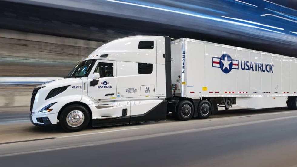 USA Truck branded tractor-trailer on road with blurred background effect