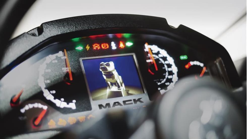 Closeup photo of a truck instrument cluster with a digital dash including an image of the Mack bulldog.