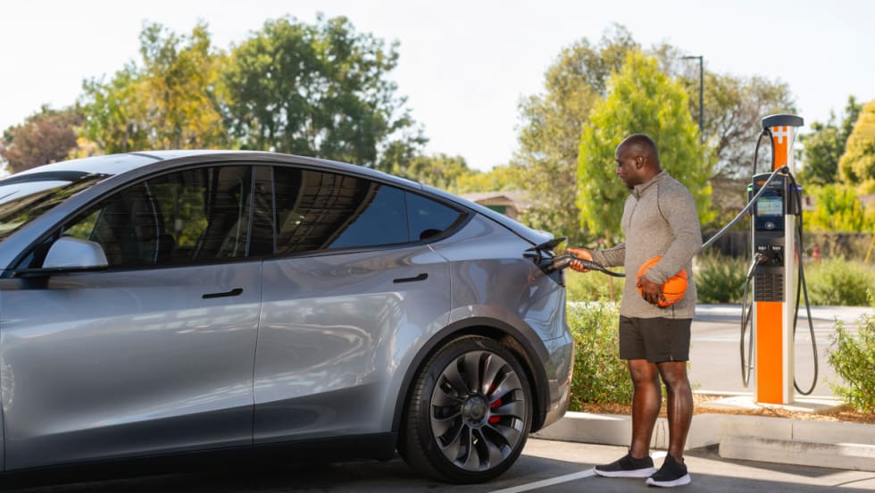Photo of a man charging an EV car.