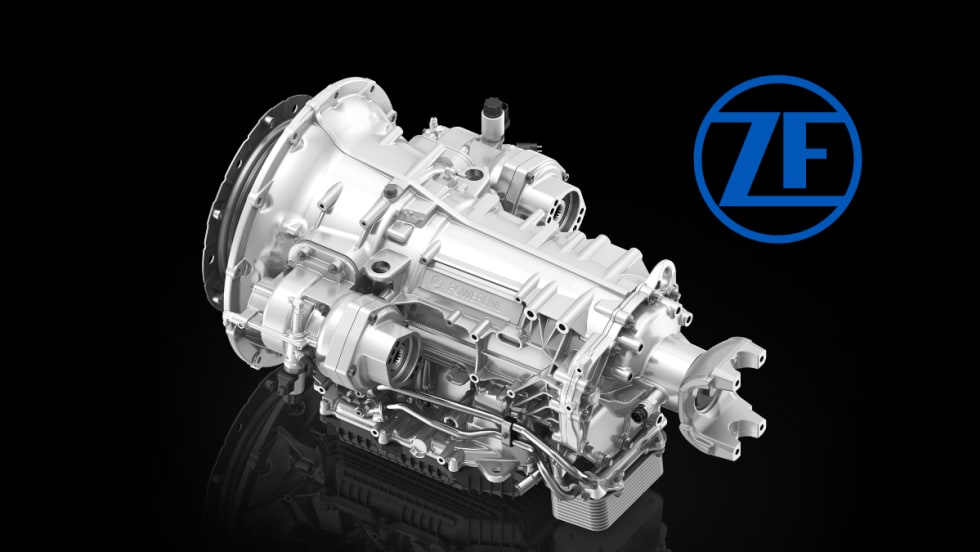 Silver truck transmission against a black background and a blue ZF logo.