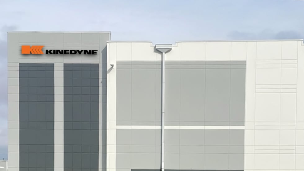 Artist's rendering of a white industrial building with Kinedyne logo.