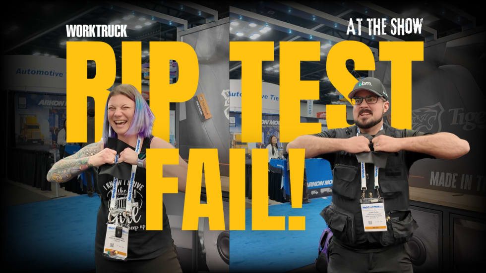 Two people at a trade show attempt to tear durable Tiger Tough seat cover fabric during a rip test challenge, but fail to rip it.