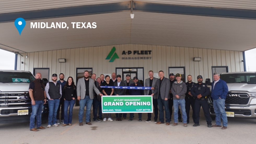 AP Fleet Management team members and local guests pose during a ribbon cutting ceremony outside the company’s new Midland, Texas, fleet facility alongside commercial pickup trucks.