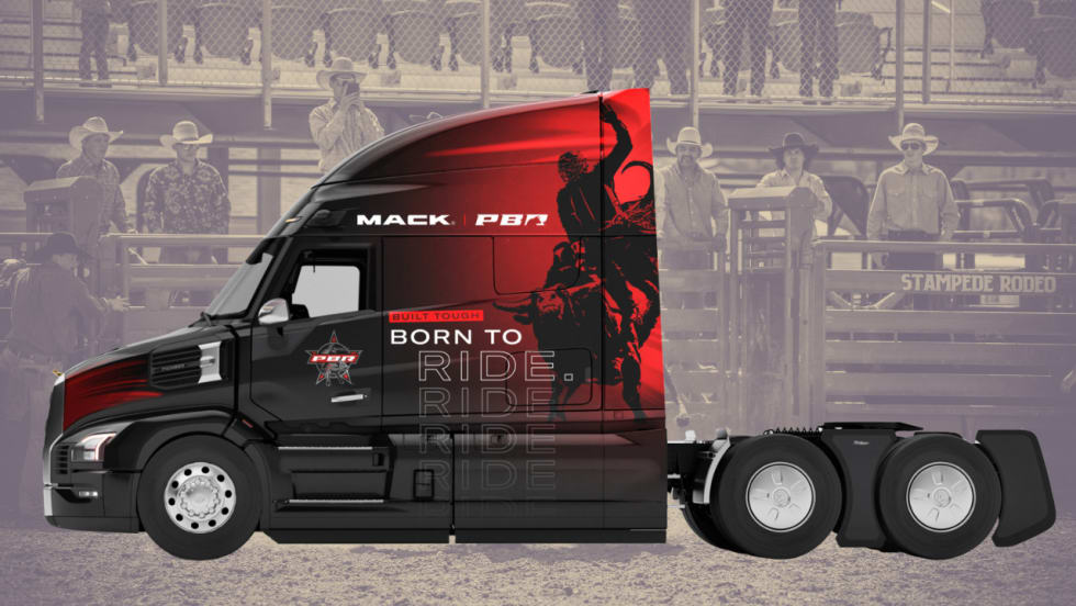 Mack Pioneer tractor features a black-and-red Professional Bull Riders design with “Built Tough, Born to Ride” graphics, displayed against a rodeo arena background with cowboys.
