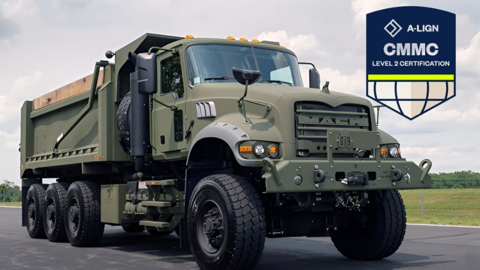 Mack Defense heavy-duty military dump truck displayed with an A-LIGN CMMC Level 2 Certification badge, highlighting the company’s cybersecurity certification.
