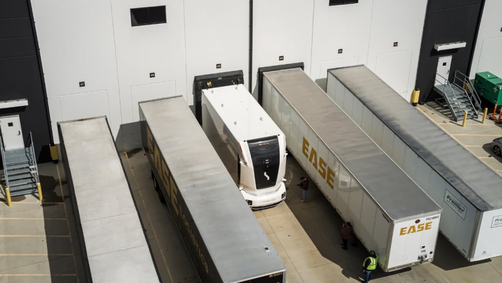 Overhead view of an Einride autonomous electric truck positioned between trailers at an EASE Logistics warehouse loading area in Marysville, Ohio.