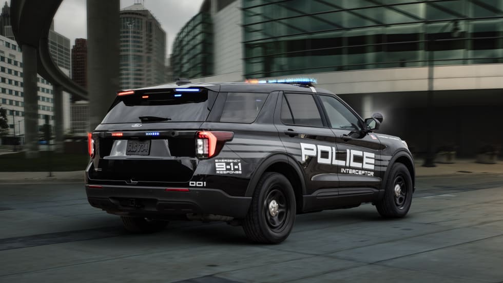 A black 2025 Ford Police Interceptor Utility is seen on a roadway with lights activated.