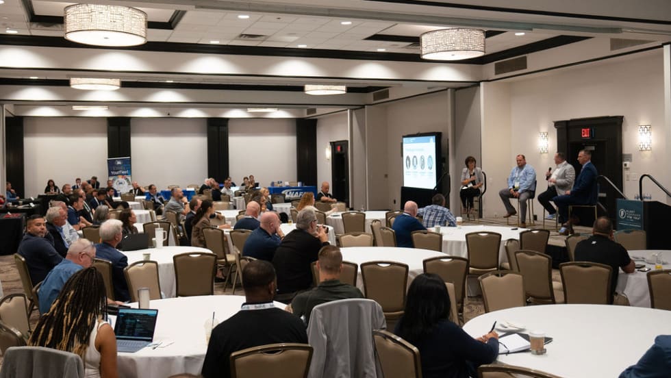 Wide shot of hotel conference room during a presentation. 